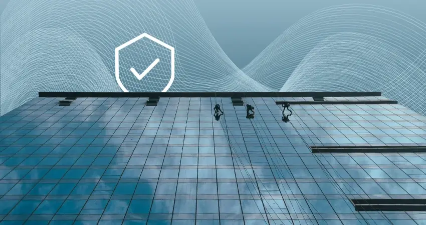 A glass facade with a rope technician working down it